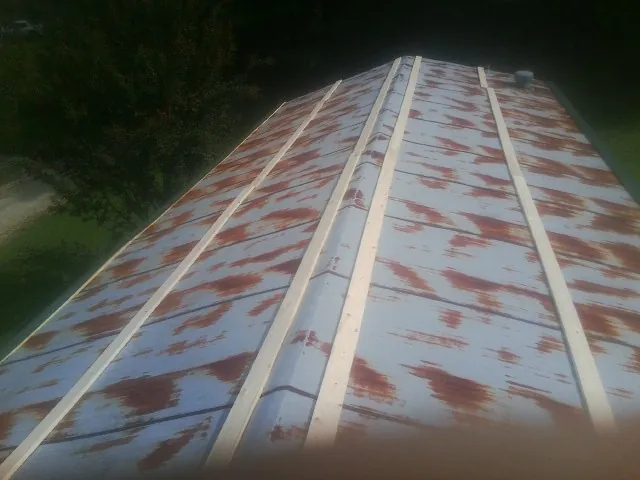 Rusted metal roof panels with new wood purlins before replacement — Storm Damage Roof Repair in Tustin by Roofing Brothers
