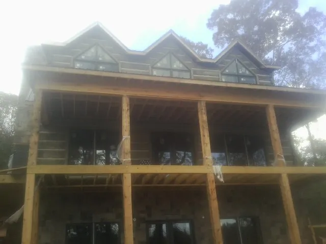 Dormers and porch framing on a large log home under construction — Roof Coating work by our crew in Tustin